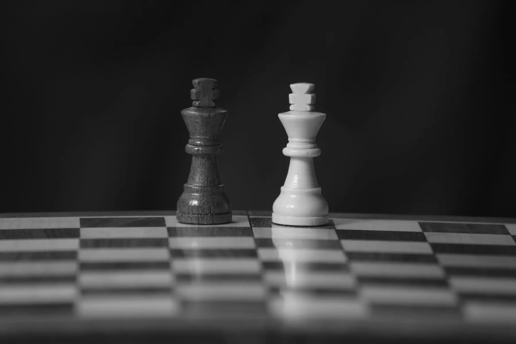 Two chess kings facing each other on a board, in black and white