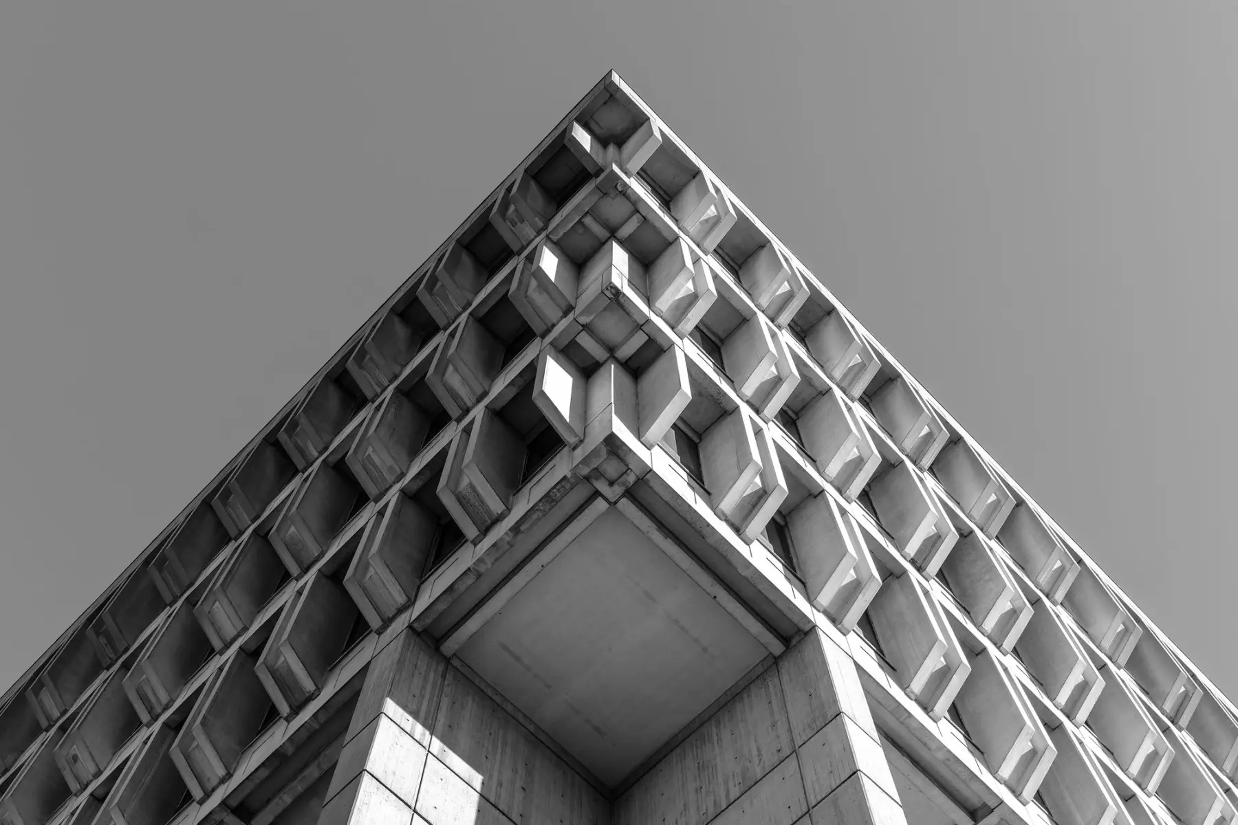 Looking up at a brutalist concrete facade in black and white